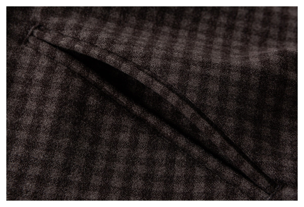 Close-up of a folded flap and seam on dark brown mottled fabric.