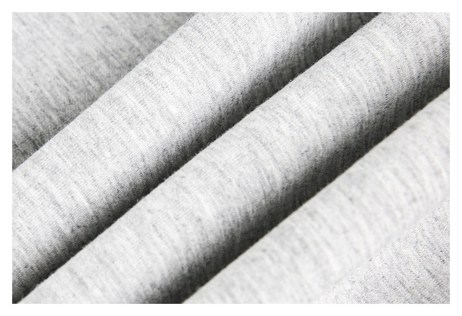 Macro view of the textured light gray heathered garment fabric folded into ridges.
