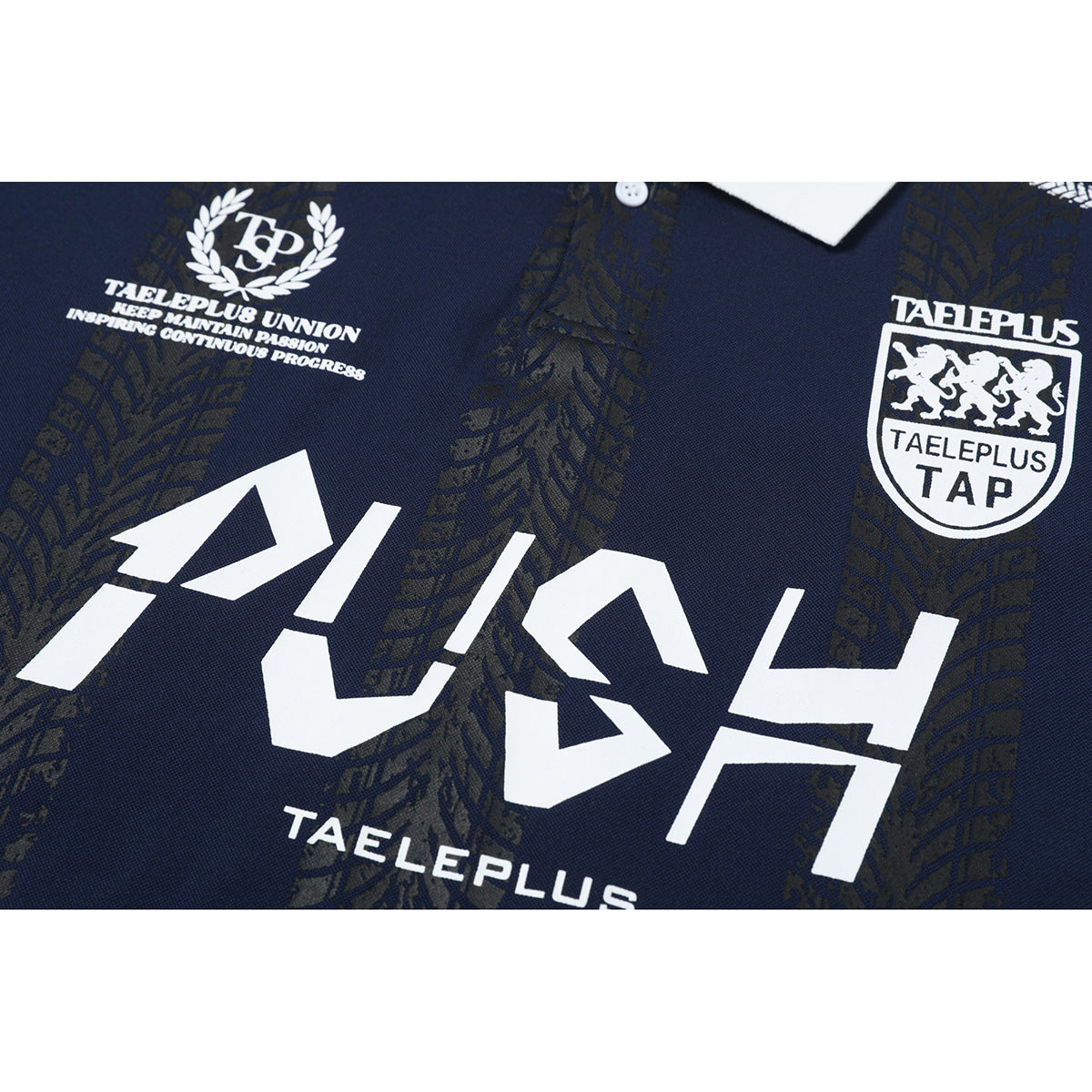 Close-up of white graphic prints and dark patterned detailing on the front of a navy polo shirt.