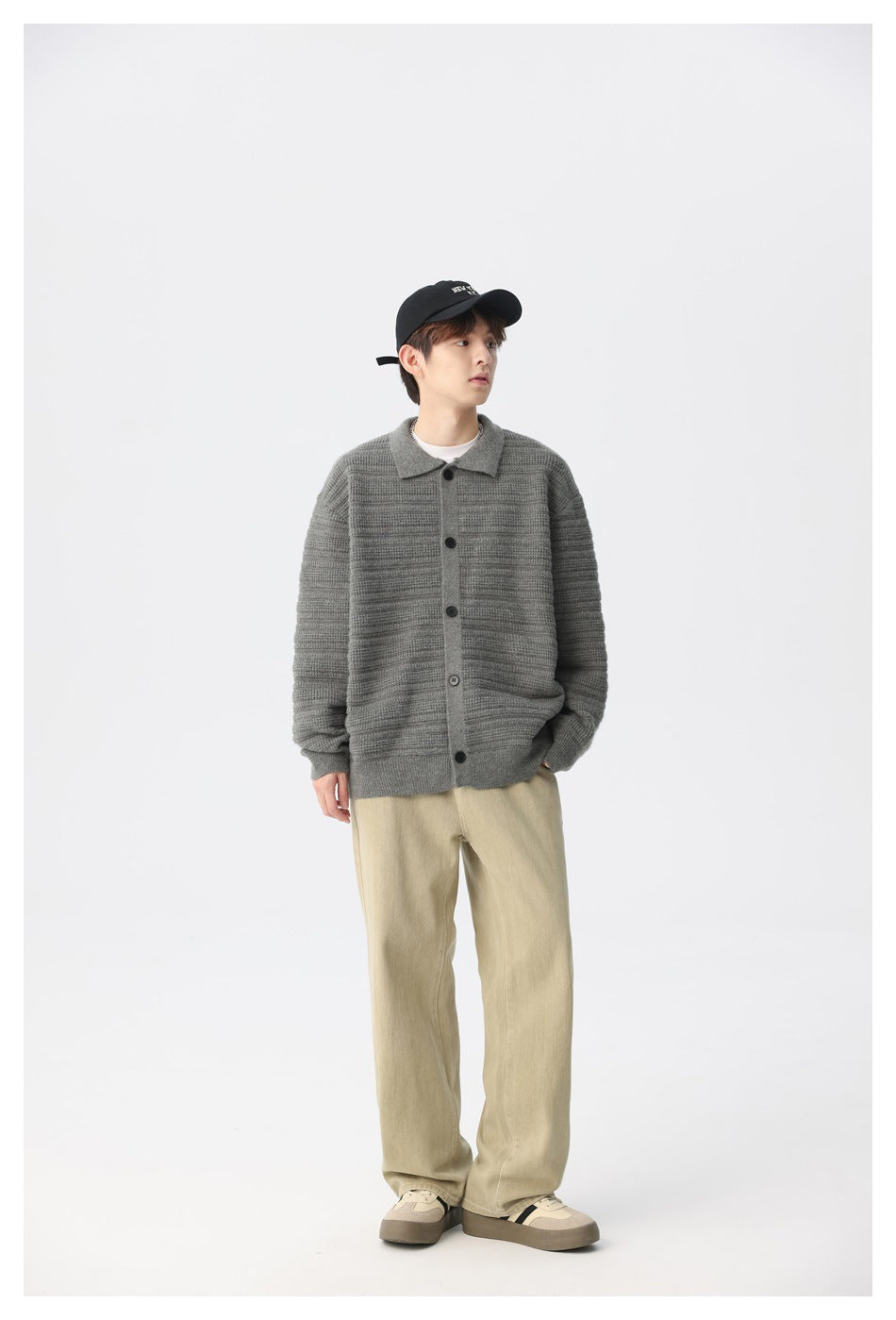 Model wearing gray textured knit button cardigan with black cap, beige wide-leg pants and sneakers