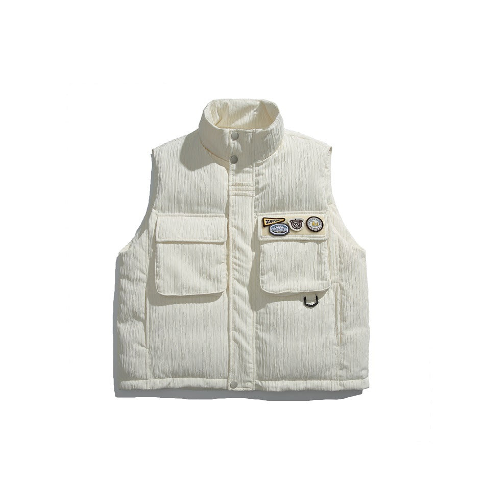 Off-white textured puffer vest with stand collar, two flap chest pockets and patches, flat front view on white