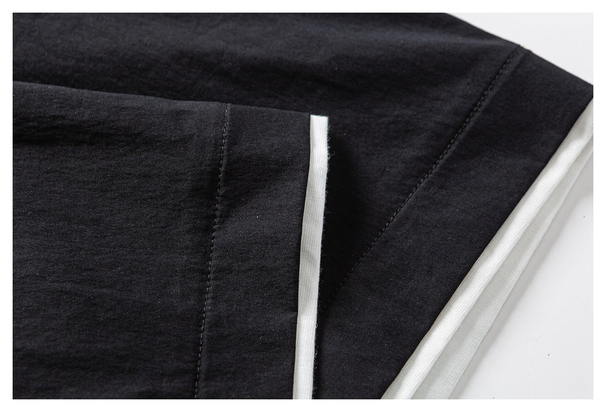 Close-up of black garment seams and a narrow white inner edge along a folded section.