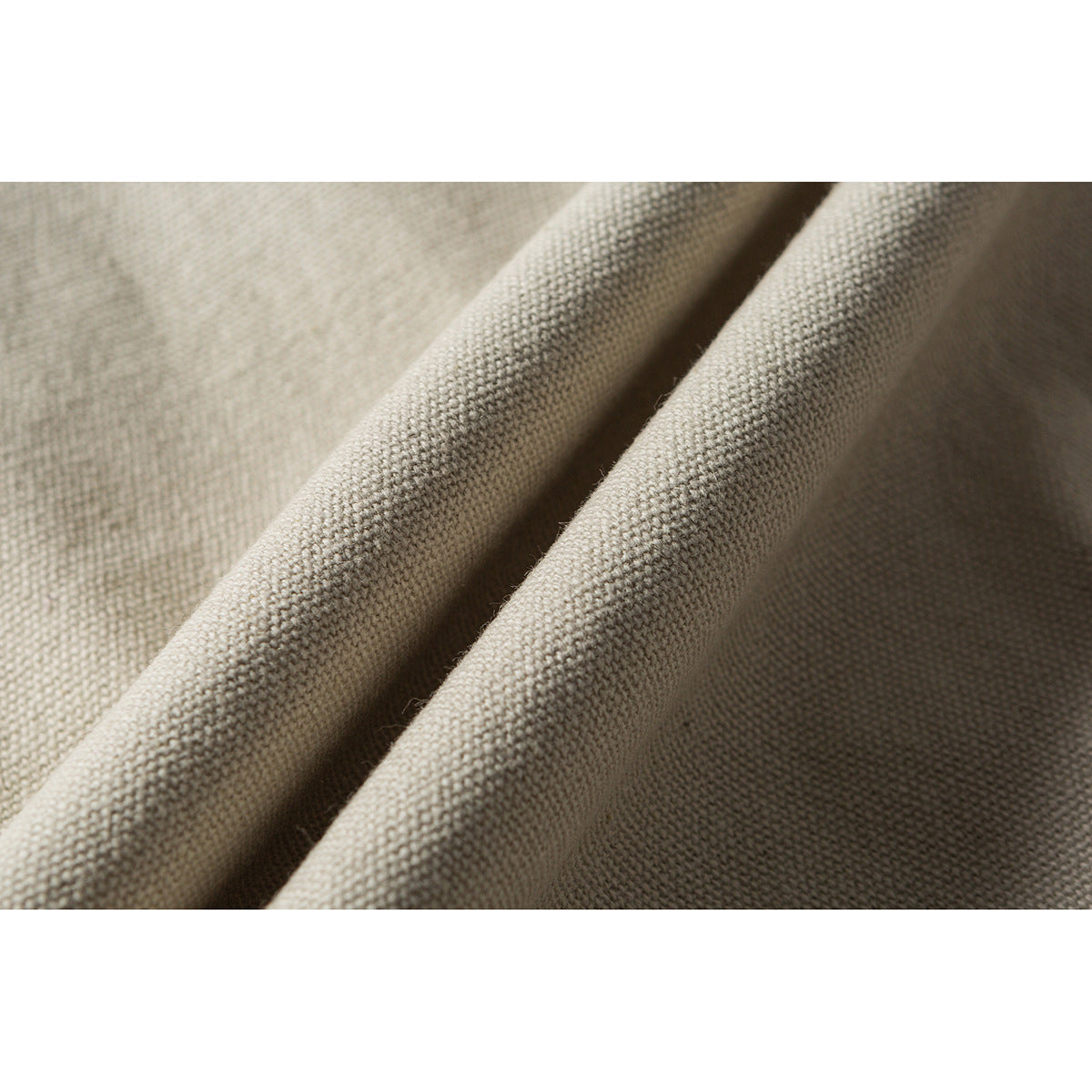 Close-up showing the textured weave and folds of off-white jacket fabric.