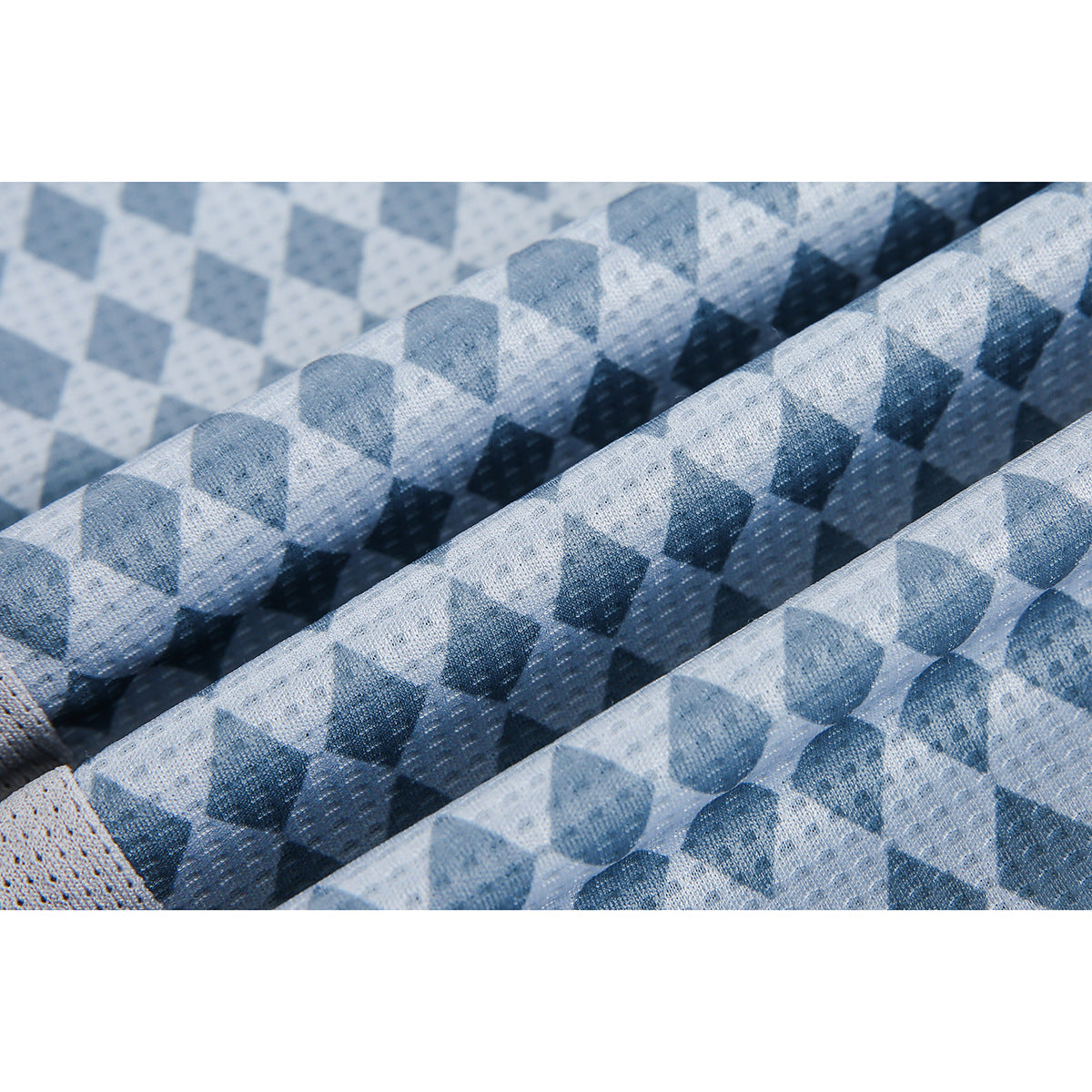 Close-up of blue and gray diamond-patterned shirt fabric gathered into folds.