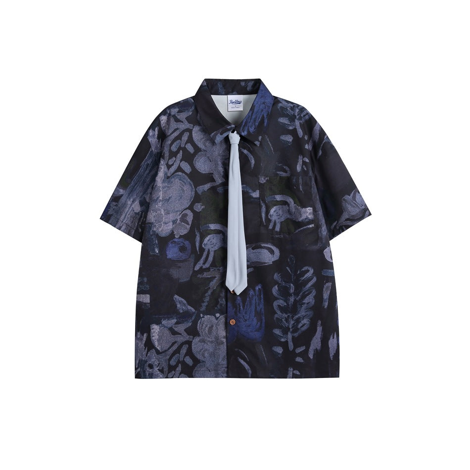 Blue-black abstract print short-sleeve shirt with light blue-gray necktie, flat lay front view