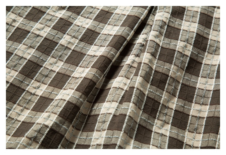 Close-up showing the drape and plaid pattern of a brown and beige garment.