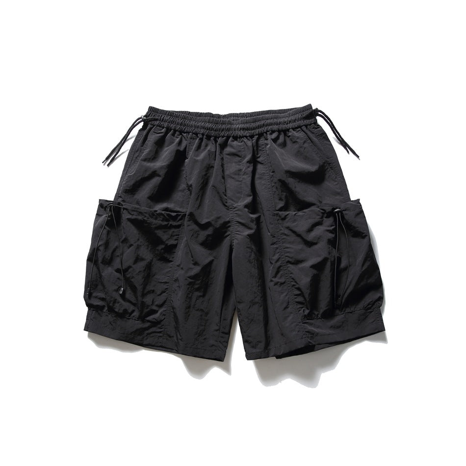 Black knee-length cargo shorts flat lay with elastic drawstring waist and oversized side cargo pockets