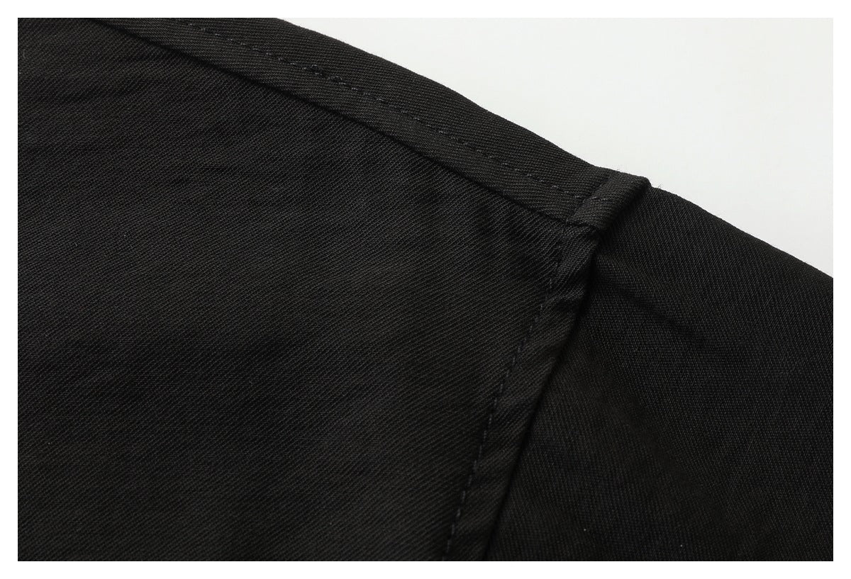 Close-up of the shoulder seam and stitching on a black shirt.