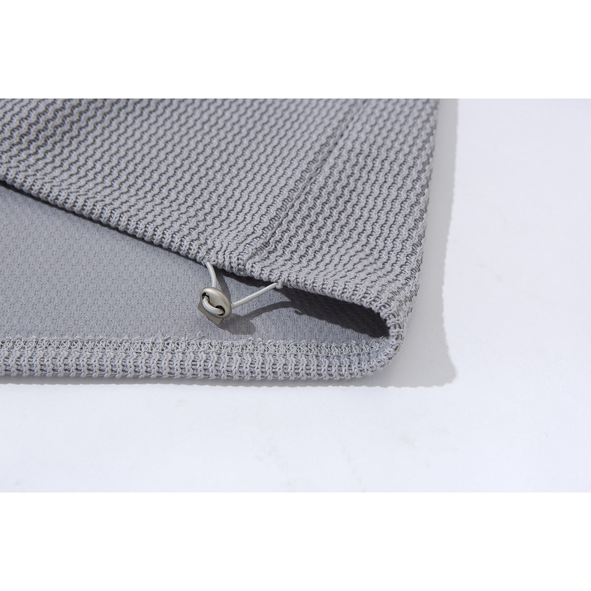 Close-up of the light gray pullover's textured hem, showing an adjustable drawcord and toggle.