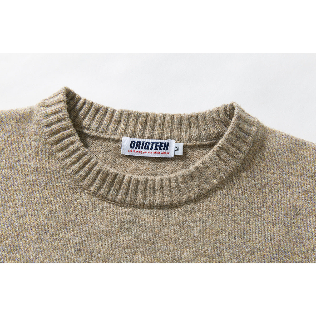 Close-up of a beige heathered sweater's ribbed crew neckline and sewn neck label.