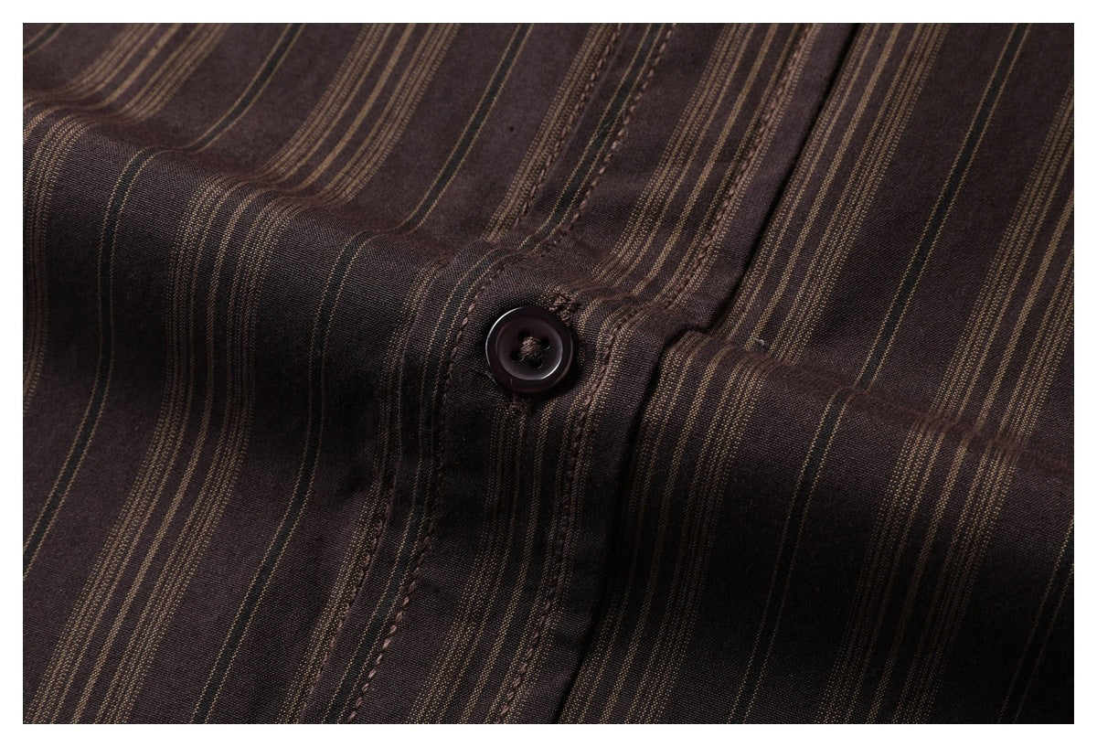 Close-up of a dark button and stitched placket on dark brown fabric with fine tan stripes.