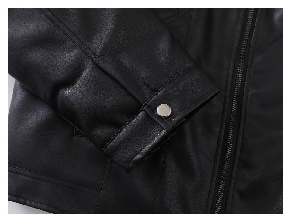 Close-up of a black jacket sleeve cuff with a round silver-tone snap beside the front zipper.