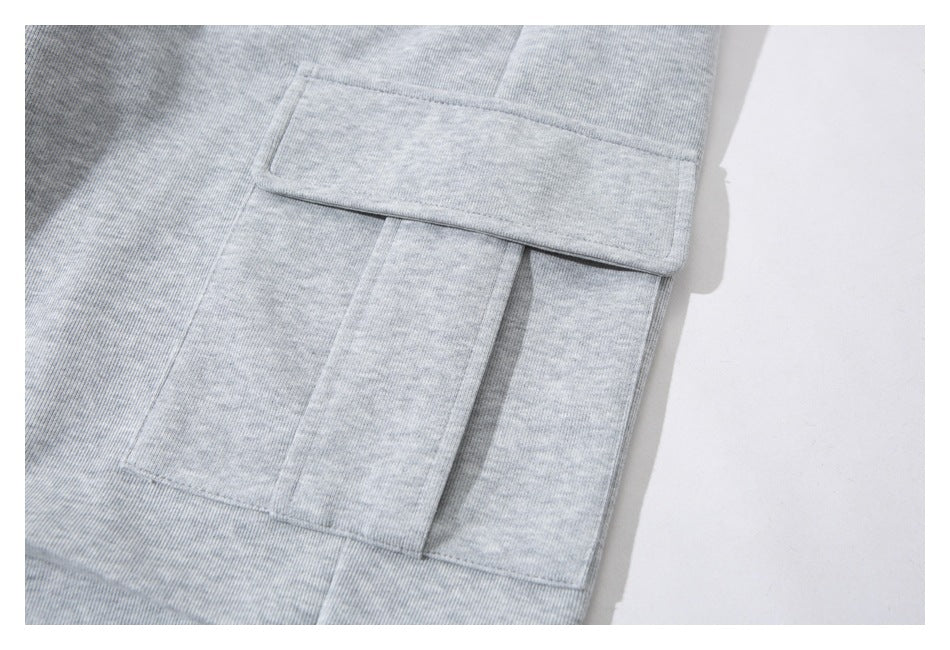 Close-up of a large flap cargo pocket on light gray heathered pants.