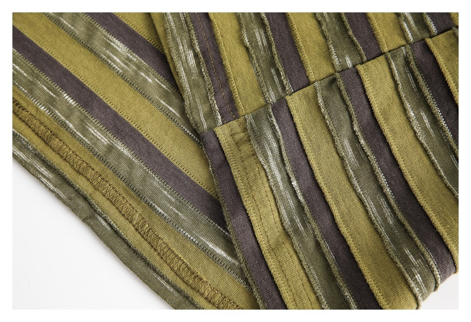 Close-up of a joined seam on olive, brown, and textured green striped shirt fabric.
