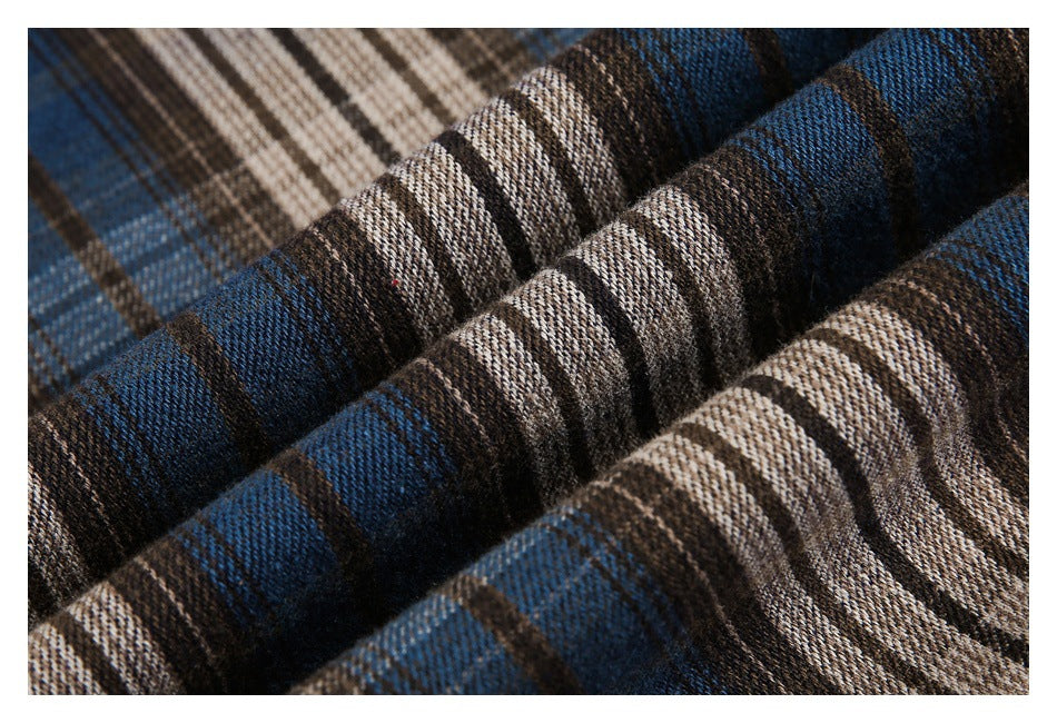 Close-up of folded plaid fabric with blue, brown, black, and cream stripes.