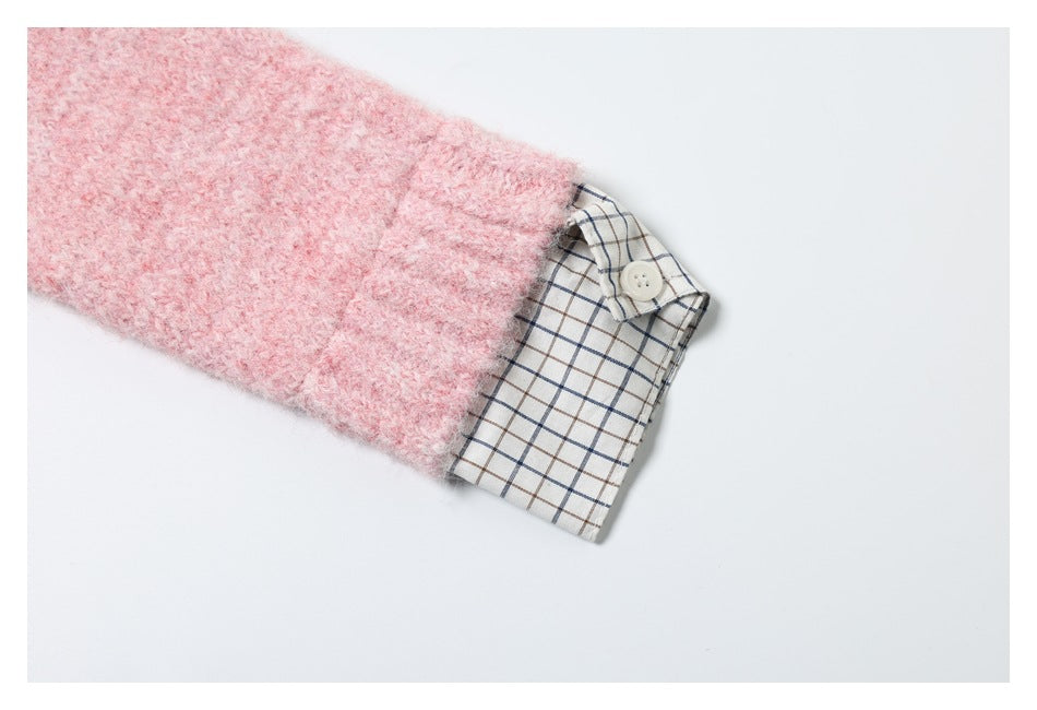 Close-up of a pink knit sleeve ending at a cuff with a cream and navy plaid inset and button.