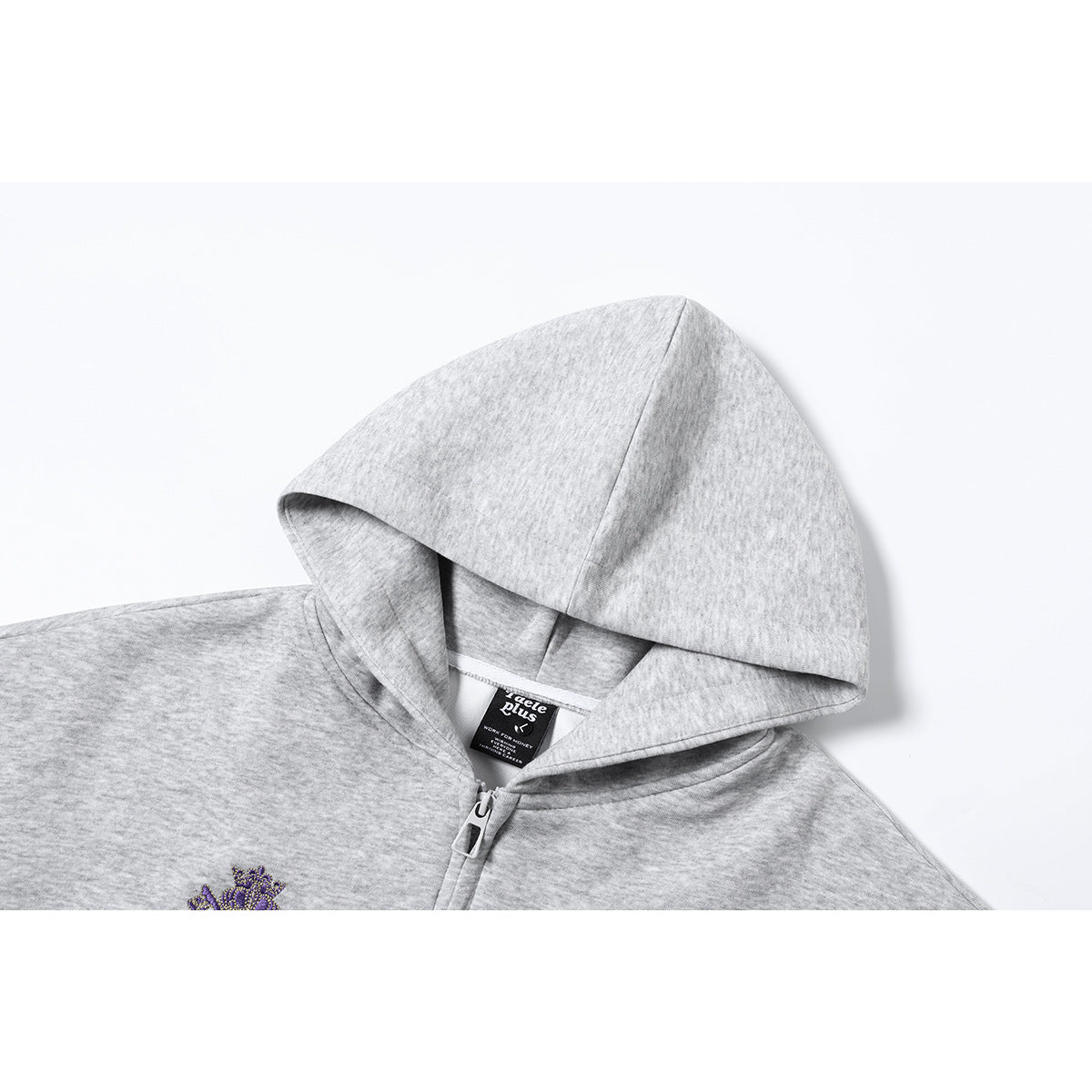 Close-up of a light gray heather zip-up hoodie showing its hood, zipper, neck label, and partial purple embroidery.