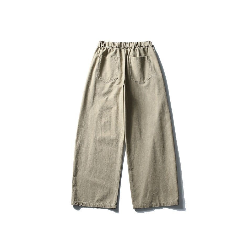 Back view of light beige wide-leg trousers with an elastic waistband and two rear patch pockets.