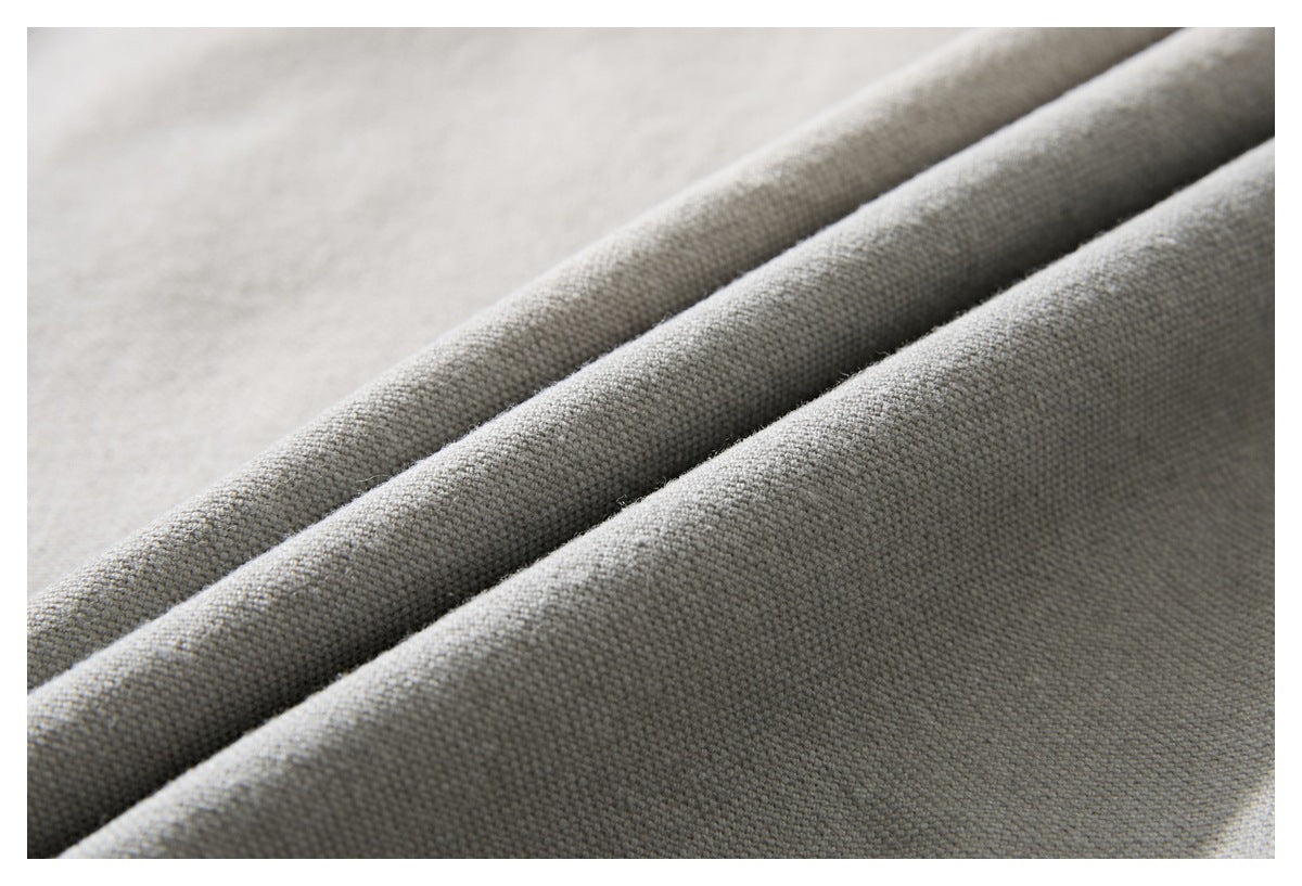 Macro view of the light gray jacket's woven fabric, shown in soft folds.
