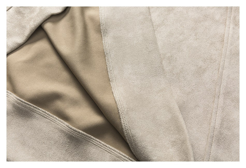 Close-up of the beige garment interior, showing an overlocked seam and inner fabric.
