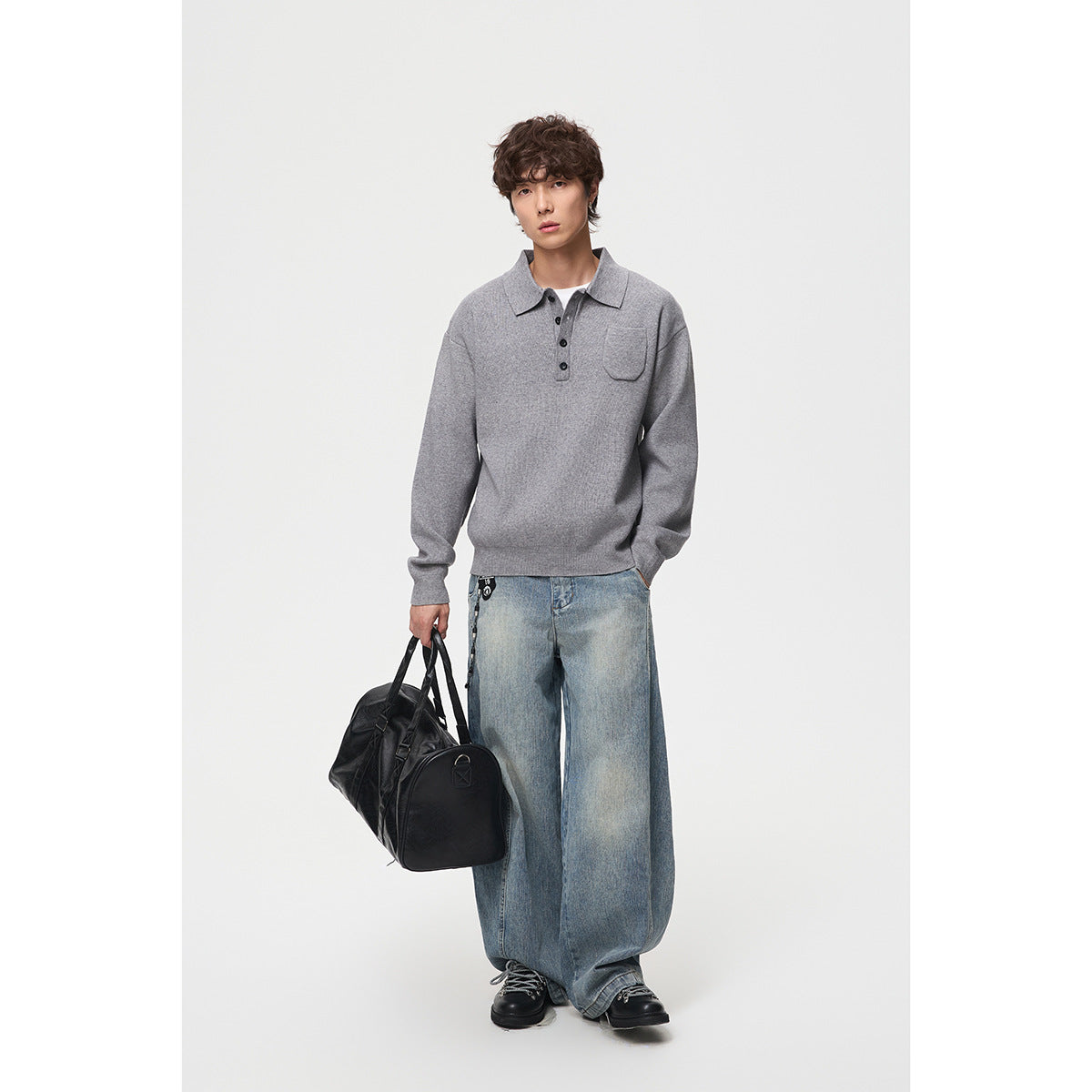 Model wearing a light gray collared pullover with a button placket and chest pocket, paired with wide-leg jeans.