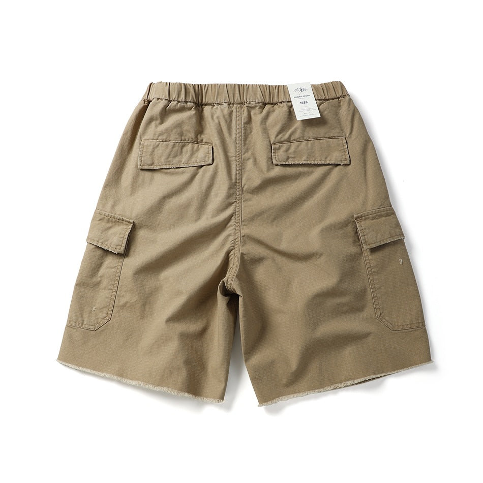 Back view of khaki cargo shorts with elastic waistband, two flap back pockets, side cargo pockets and frayed hem