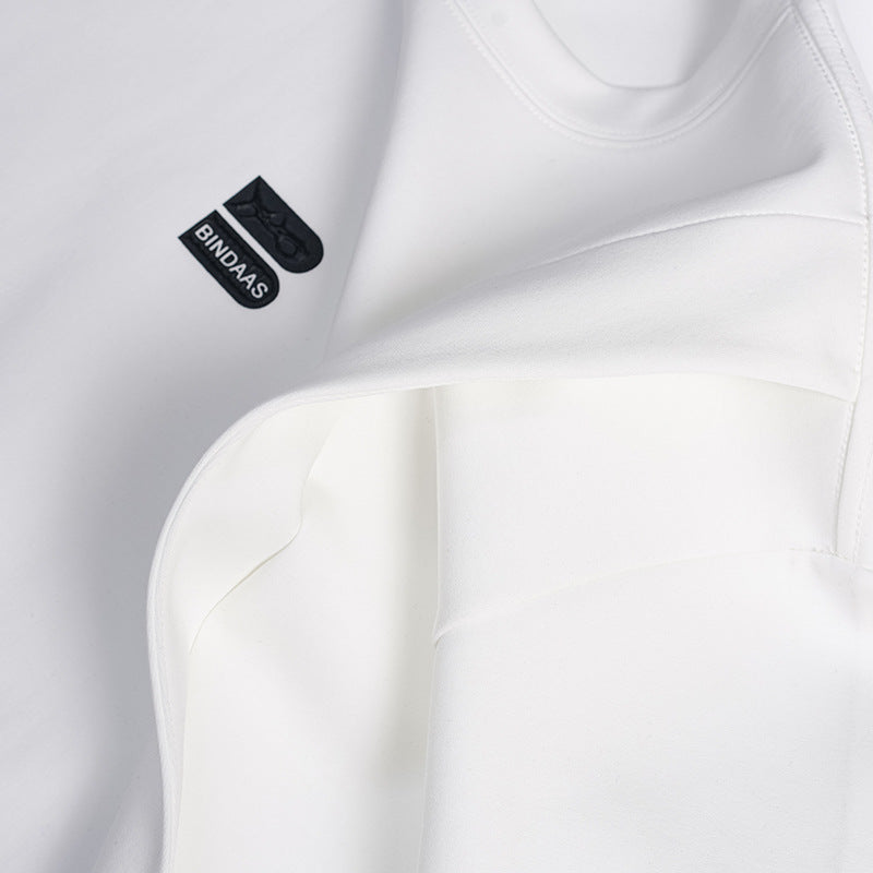 Close-up of a white T-shirt with curved seam panels and a small black chest logo.
