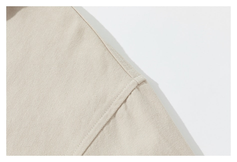 Close-up of a cream shirt shoulder seam and sleeve attachment.