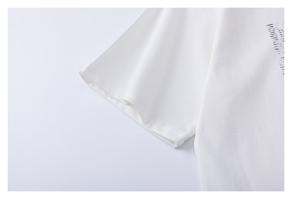 Close-up of a white short sleeve and its stitched hem, with a small portion of the black print visible.