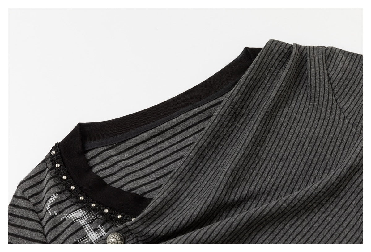 Close-up of a charcoal striped top showing its black neckline trim, beaded edging, and decorative button.