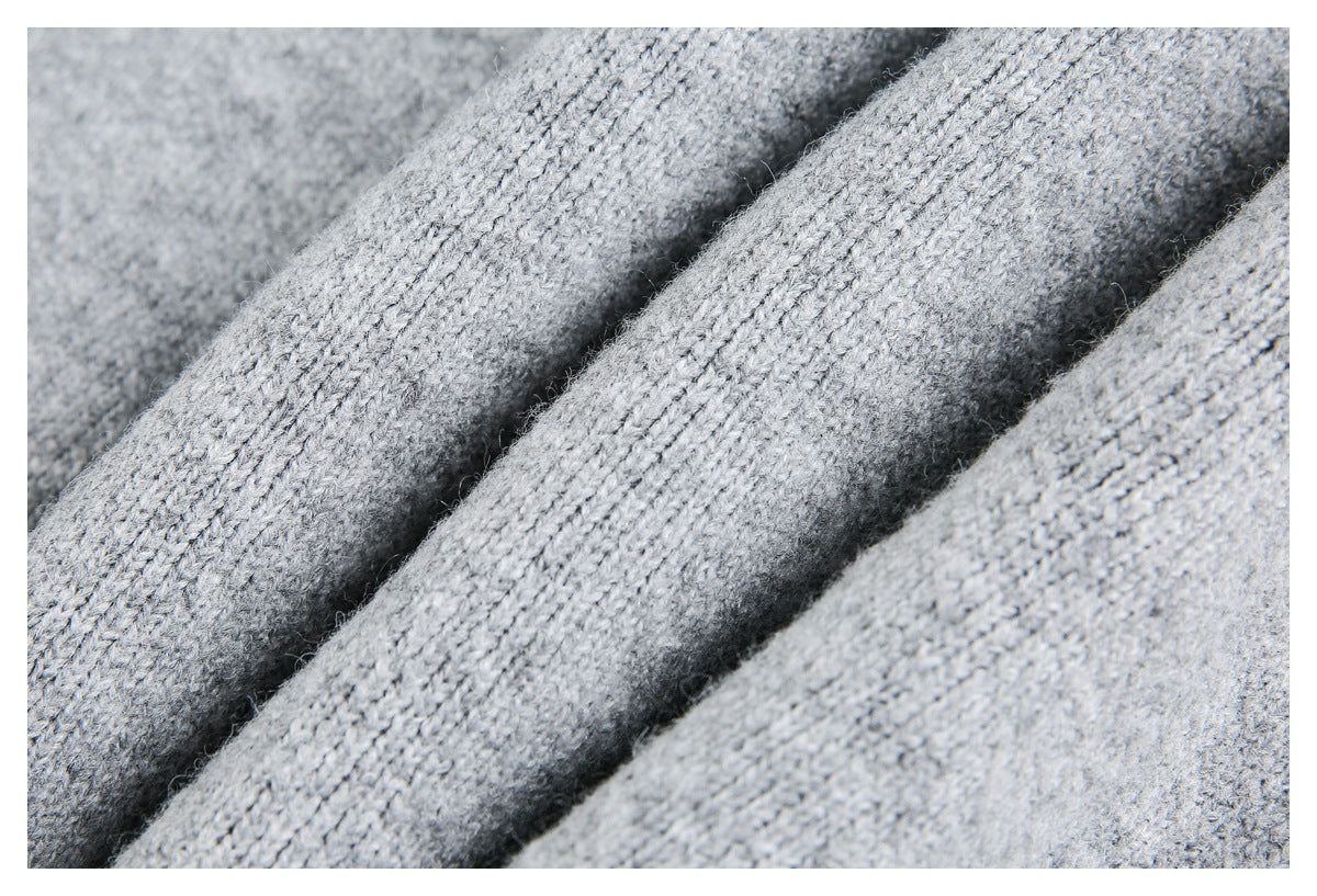 Close-up of light gray knit fabric showing its textured stitches and soft-looking fibers.