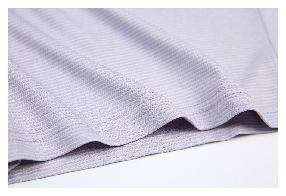 Close-up of a pale gray-lavender textured shirt hem with a curved double-stitched edge.