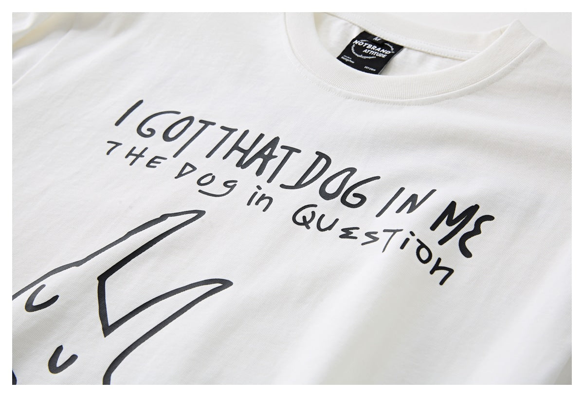 Close-up of a white T-shirt collar and black front graphic with handwritten text and a large abstract illustration.