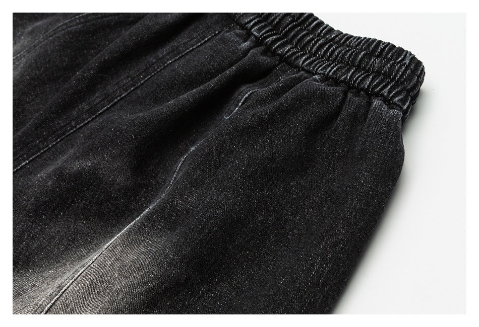 Close-up of black pants showing the elastic waistband and curved stitching.