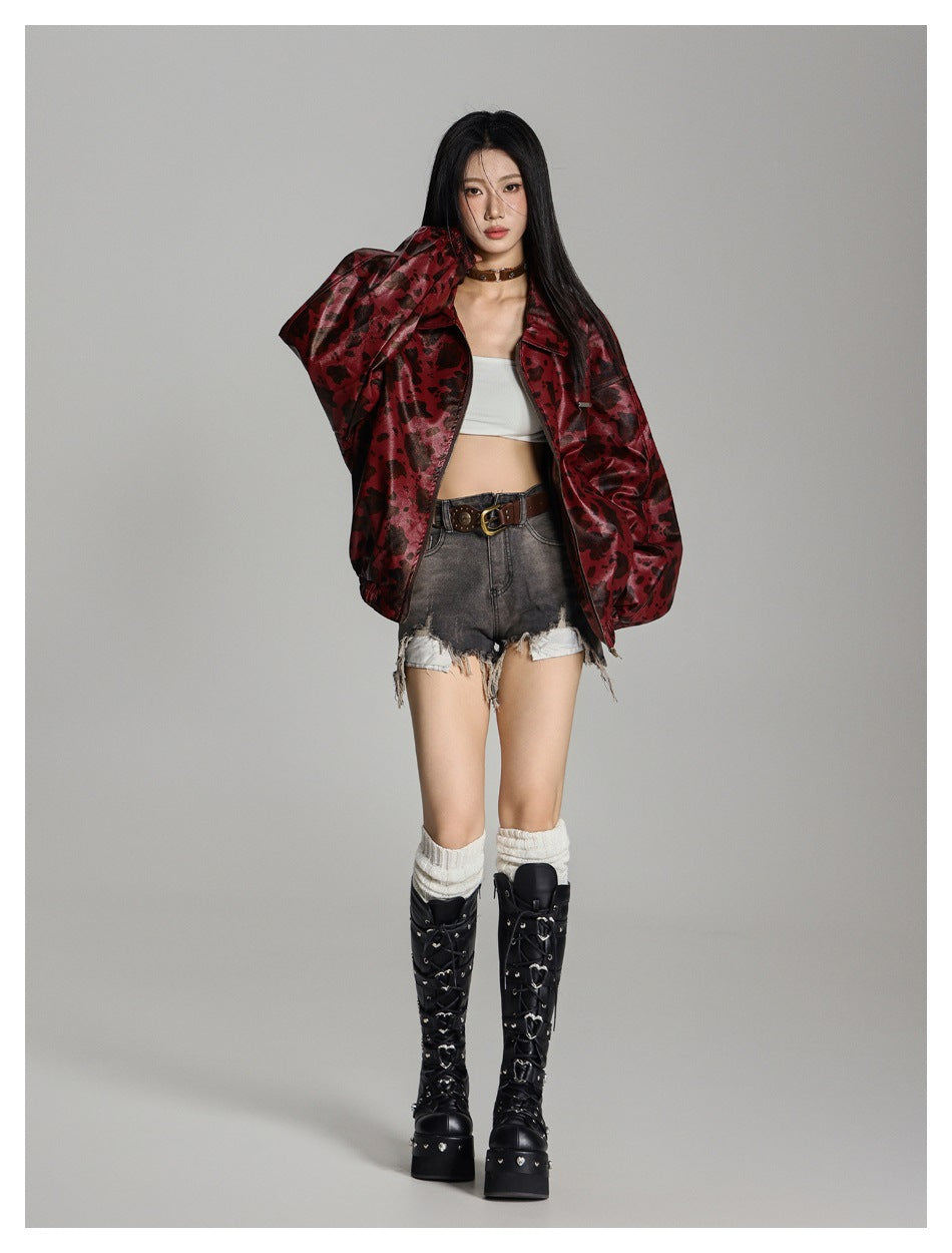 Model wearing an open red animal-spot jacket with a white top, denim shorts and black lace-up platform boots