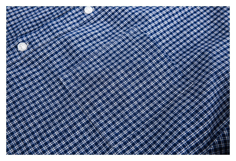 Close-up of the checked shirt fabric and stitched chest pocket.