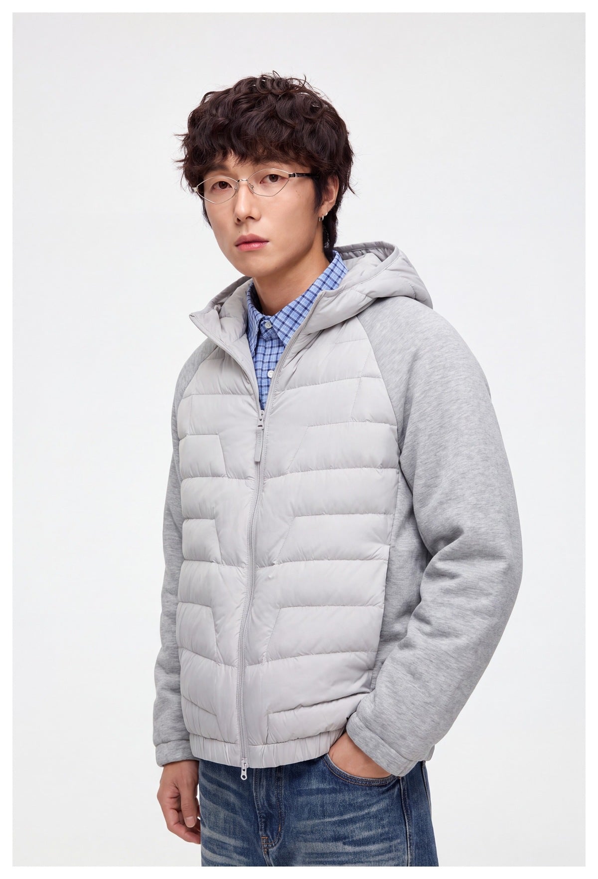 Closer view of a model wearing the light gray quilted hooded jacket with heather gray sleeves.