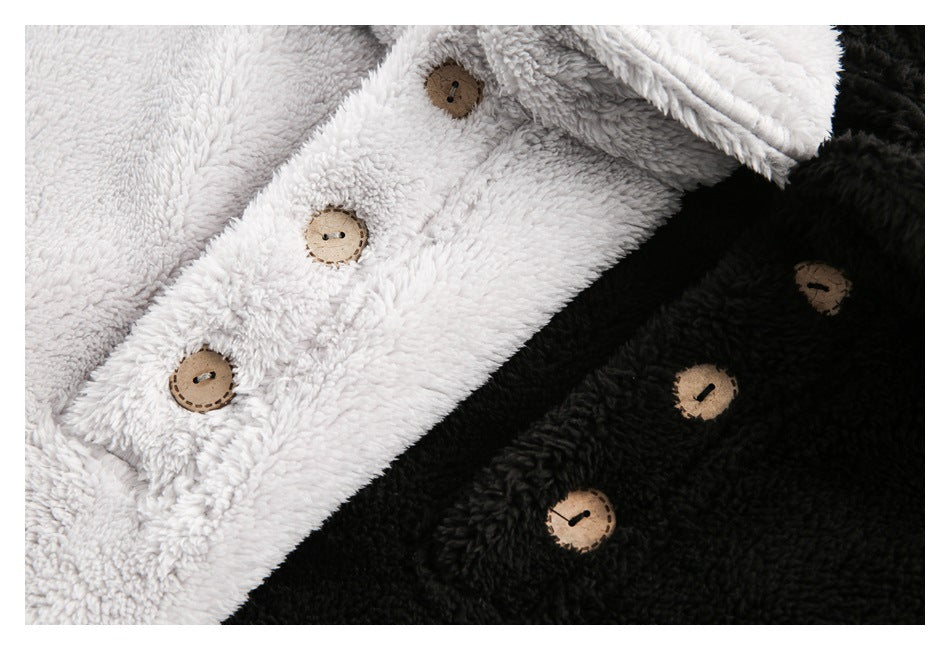 Close-up of white and black plush garments with round tan buttons.