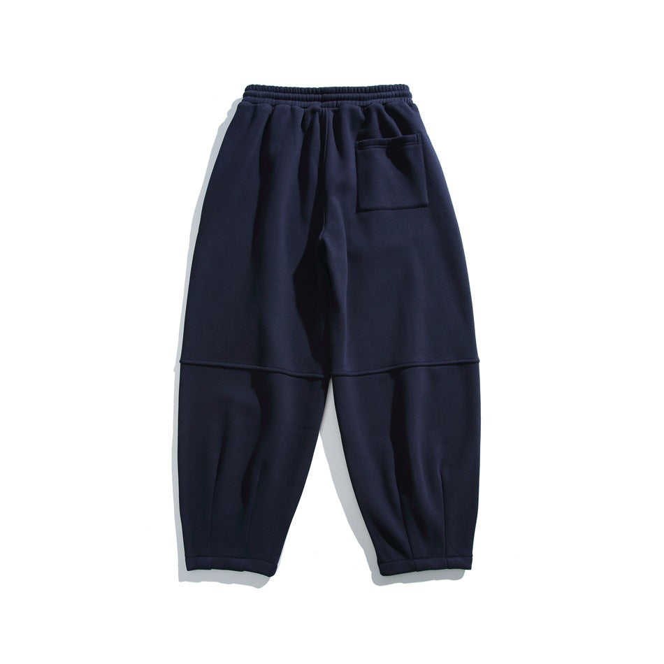 Back view of navy relaxed-fit joggers with an elastic waistband, rear patch pocket and paneled legs.