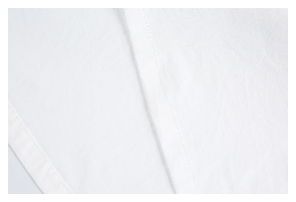 Close-up of white garment fabric with a long diagonal stitched seam.