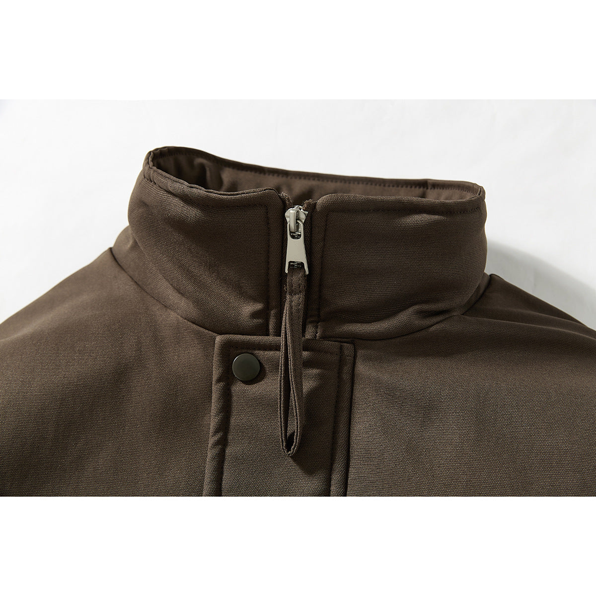 Close-up of a dark brown jacket’s stand collar, front zipper, and snap-button placket.