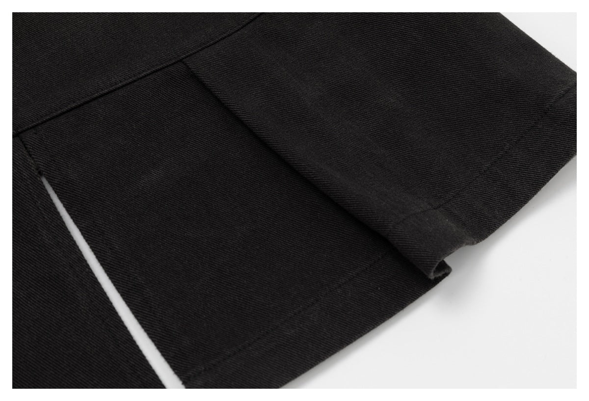 Close-up of a black garment hem and overlapping seam detail.