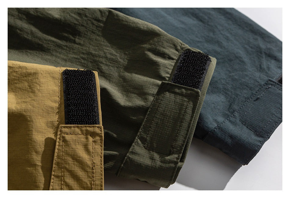 Close-up of olive, tan, and charcoal garment panels with black hook-and-loop fastening tabs.