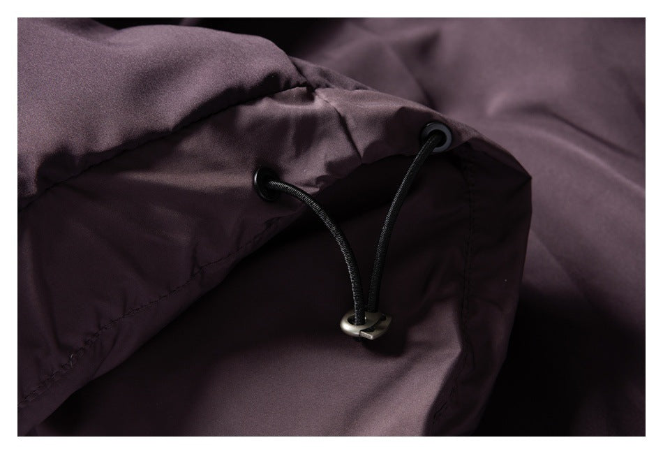 Close-up of two black drawcords threaded through metal eyelets on dusty mauve fabric.