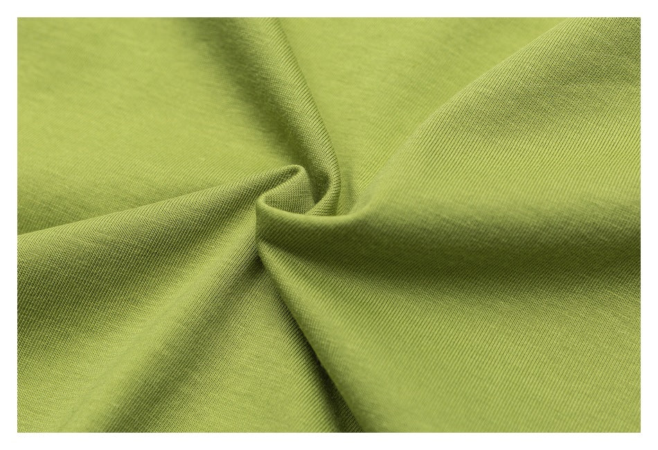 Close-up of lime-green fabric gathered into soft folds, showing its fine knit texture.