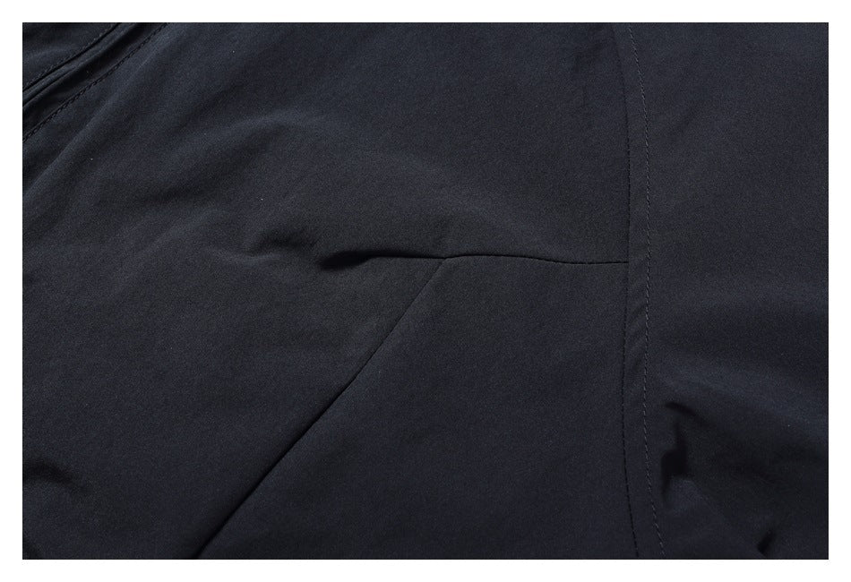 Close-up of dark trousers showing a curved seam and part of a pocket opening.