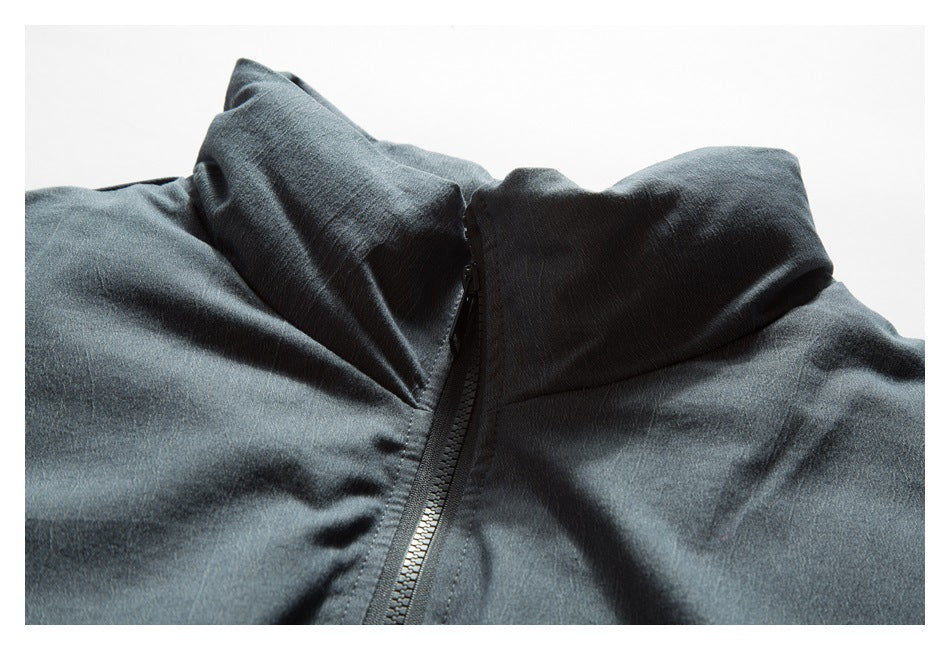 Close-up of a dark charcoal jacket’s raised collar and front zipper.