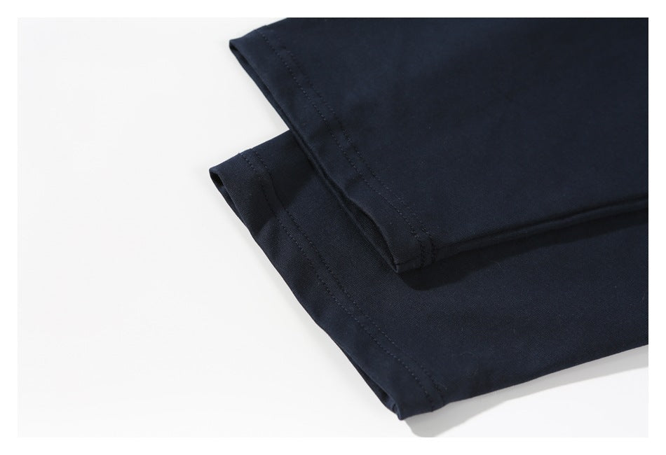 Close-up of a folded dark navy garment showing stitched hems against a white background.