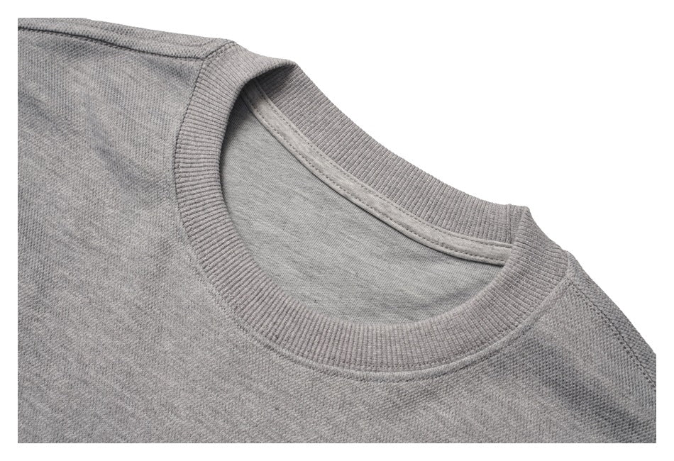 Close-up of a gray sweatshirt's ribbed crew neckline and shoulder seam.