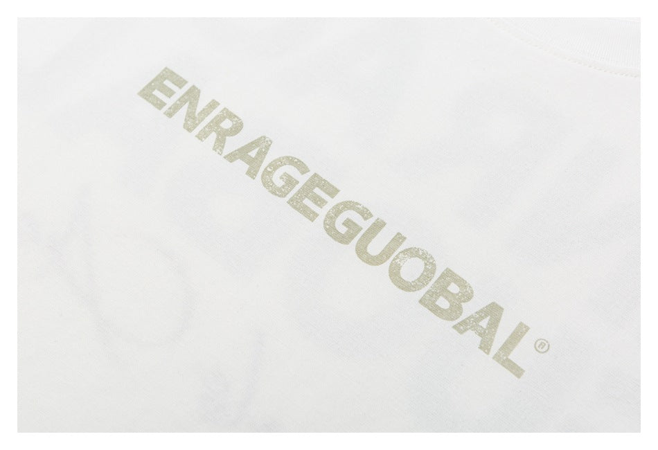 Close-up of pale lettering reading “ENRAGE GLOBAL” printed on white T-shirt fabric.